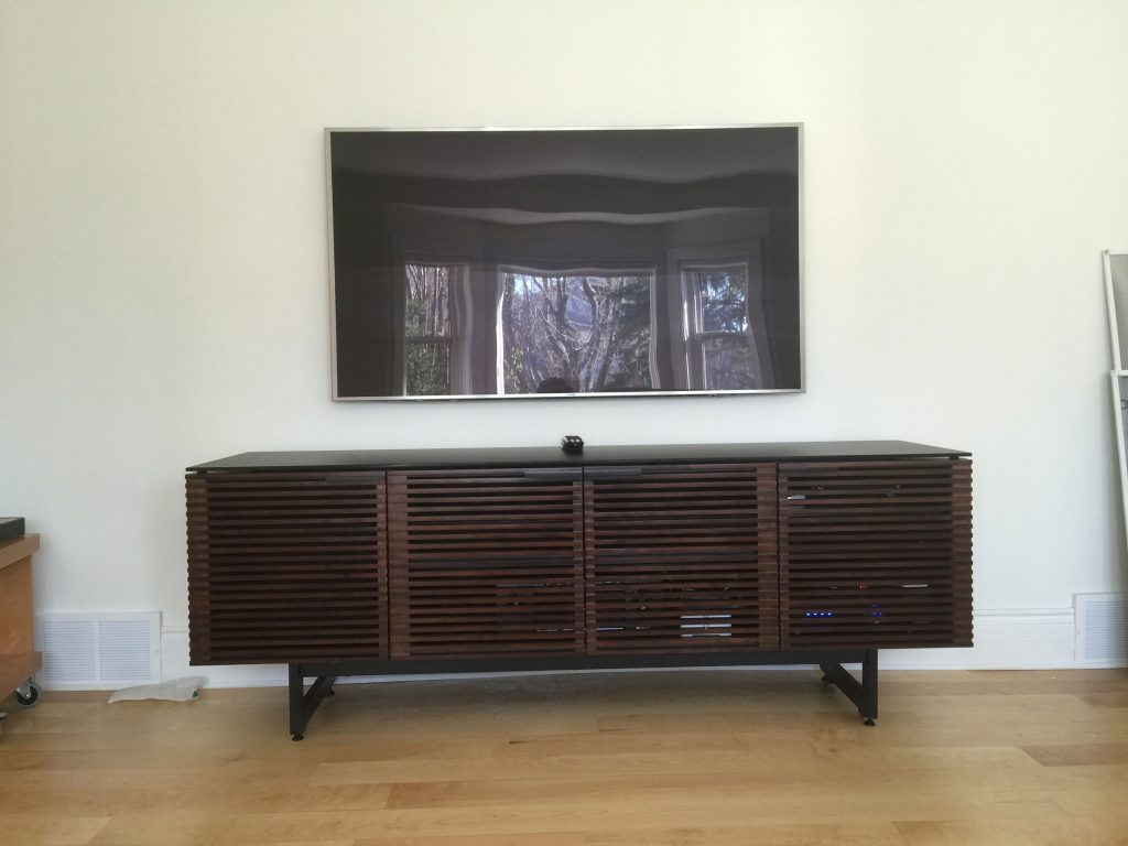 TV wall mount installation with Sonos audio and control equipment hidden in below cabinet