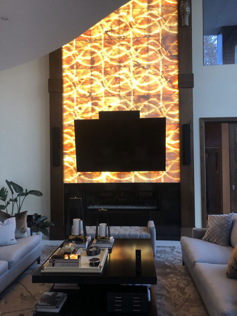 TV mounted on lumanous stone with lighting control by Lutron